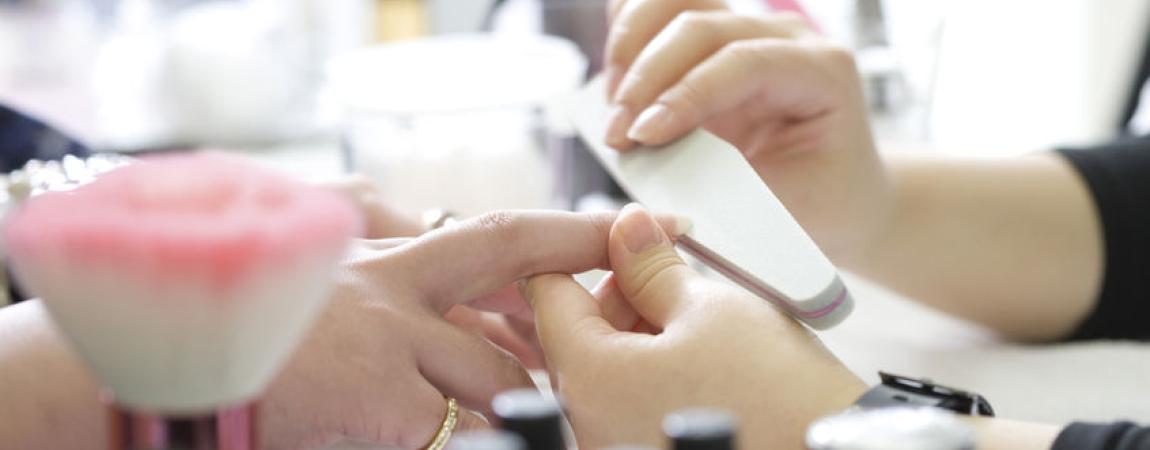 Woman at a nail salon getting her nails filed