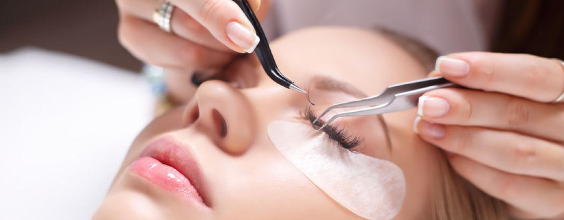 Woman putting eyelash extensions on another woman